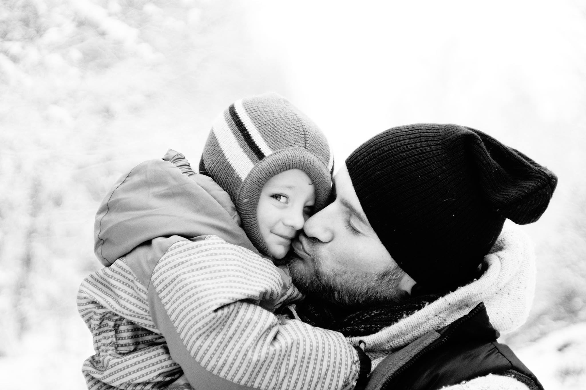 Vater und Kind in einem innigen Moment bei einem Familienshooting im Schnee